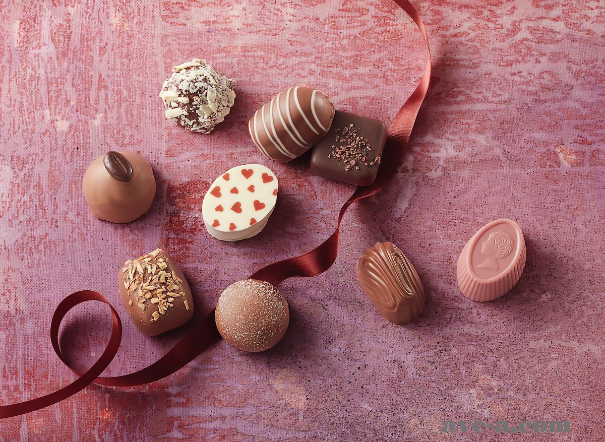 ピンクの天板にチョコレートを並べてリボンを添えて、バレンタインのカタログ用イメージ写真